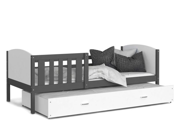 Białe łóżko dziecięce z szarą barierką i dekoracyjną poduszką