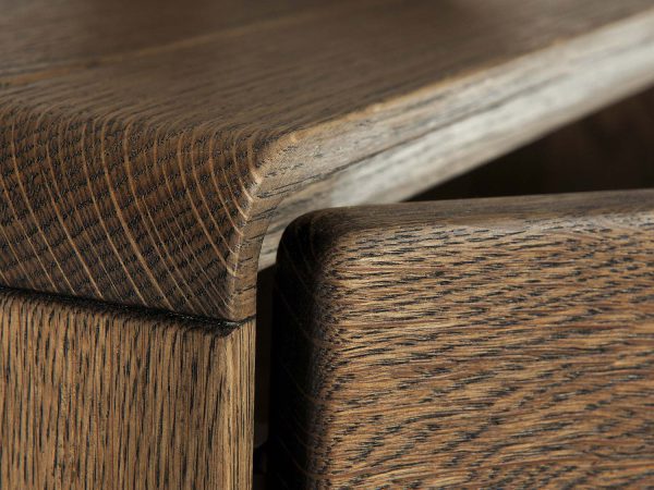 Zbliżenie na zaokrąglony narożnik komody – struktura ciemnego drewna dębowego