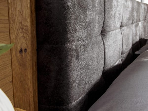 Zbliżenie na tapicerowane wezgłowie łóżka z tkaniny typu welur