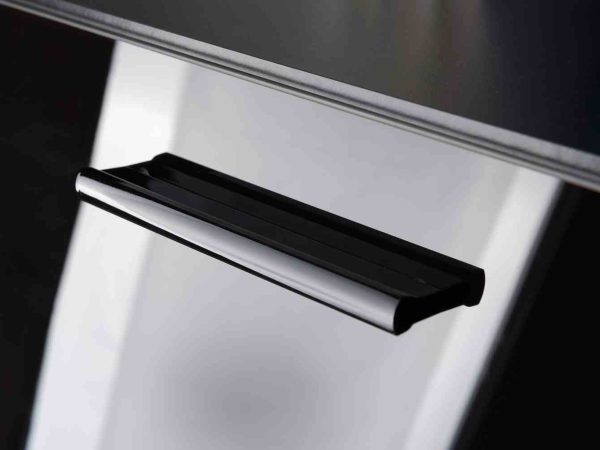 Zbliżenie na czarny uchwyt w białej szafce z połyskiem