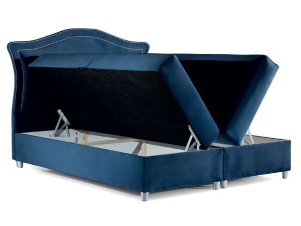 Granatowe łóżko tapicerowane z otwartym pojemnikiem na pościel