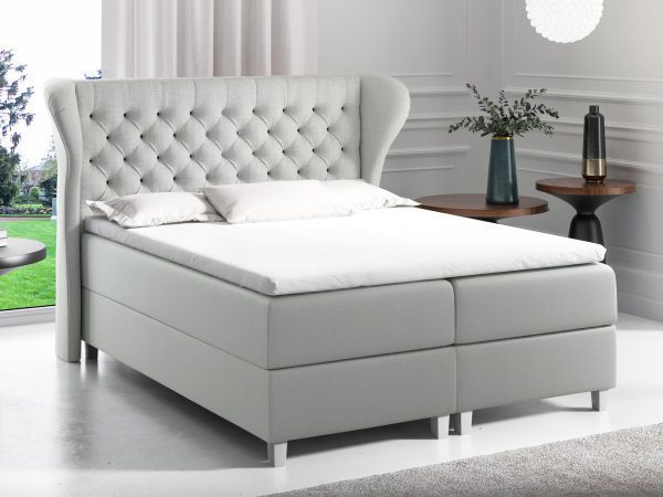 Jasnoszare łóżko z wezgłowiem i chromowanymi nóżkami