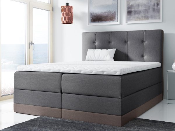 Szare łóżko z brązowym dołem i klasycznym pikowaniem