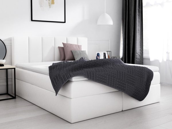 Białe łóżko kontynentalne z ozdobnym zagłówkiem i szarą narzutą