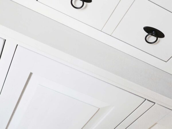 Detal uchwytu meblowego w kolorze czarnym na białym froncie