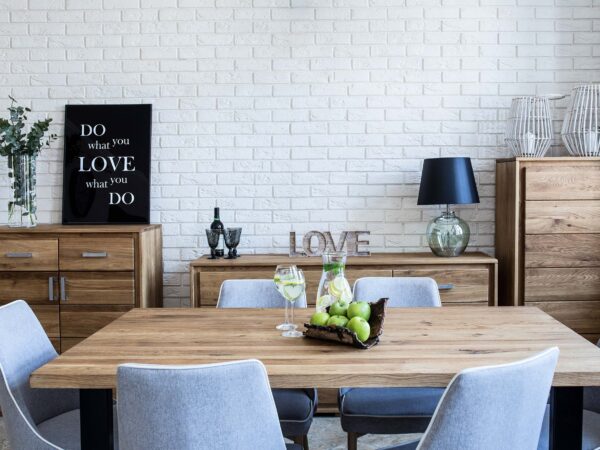 Stół jadalniany z dekoracją kwiatową i lampą, ściana z białej cegły