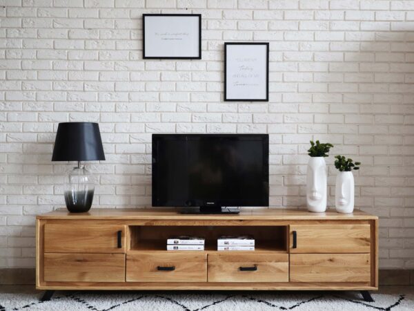 Nowoczesne wnętrze z szafką RTV z drewna, dekoracje na ścianie i jasna cegła