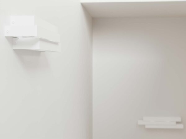 Kinkiet ścienny zamontowany w narożniku minimalistycznego wnętrza