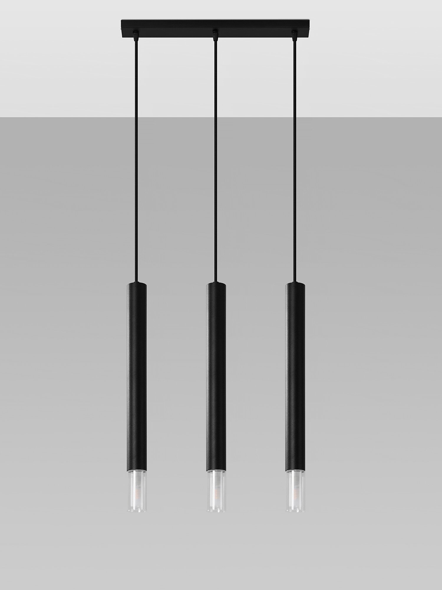 Trzy lampy wiszące w kolorze czarnym na tle szarej ściany