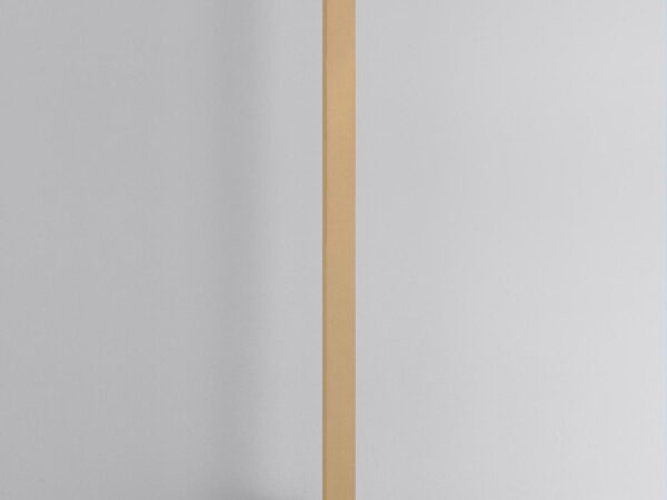 Złoty kinkiet LED oświetlający gładką białą ścianę