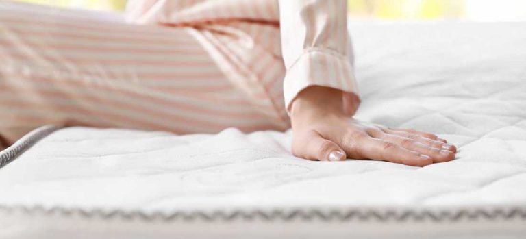 Kobieta dotykająca materaca testując jego miękkość