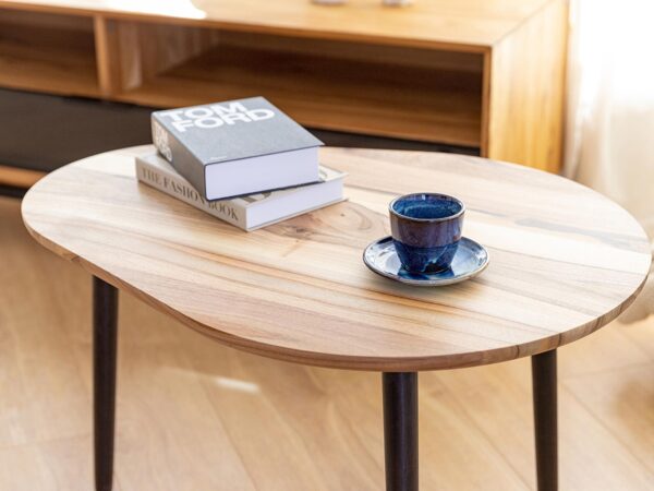 Zbliżenie na blat stolika kawowego z książką i filiżanką na tle białej zasłony