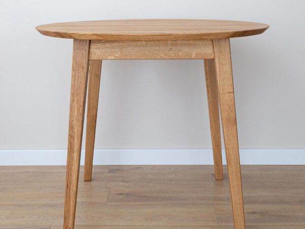 Stół okrągły w jasnym wnętrzu z drewnianą podłogą