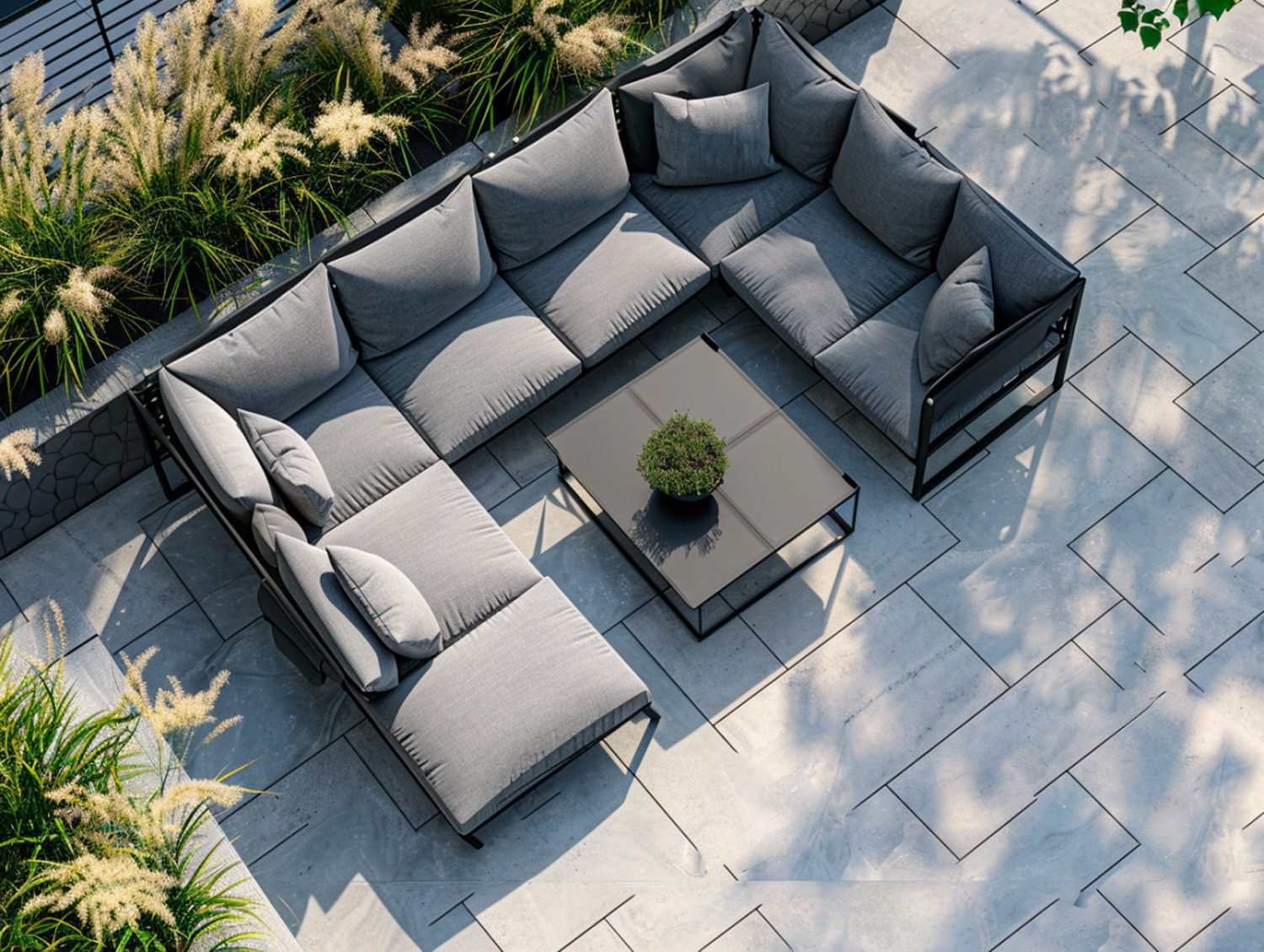 Duży narożnik ogrodowy z szarymi poduchami i stolikiem na tarasie