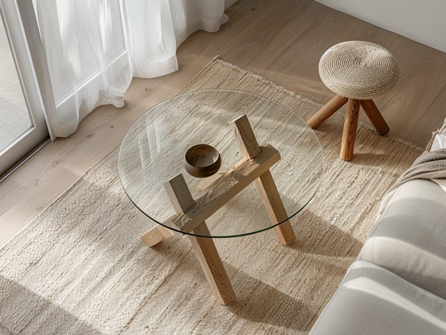 Okrągły stolik z przezroczystym blatem szklanym i drewnianymi nogami