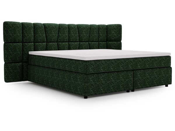 Ciemnozielone łóżko z ozdobnym zagłówkiem i grubym materacem