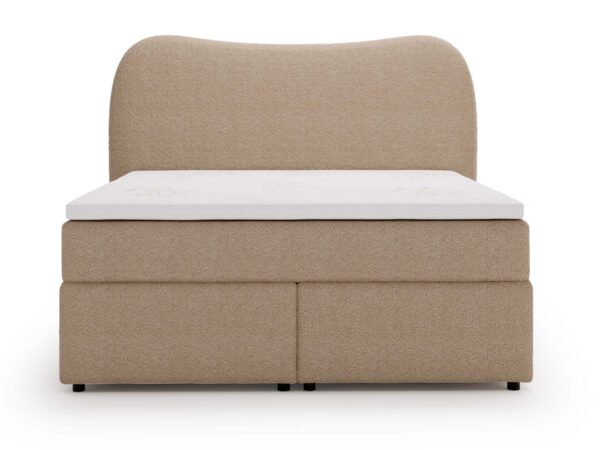 Beżowe łóżko z grubym materacem i wysokim zagłówkiem