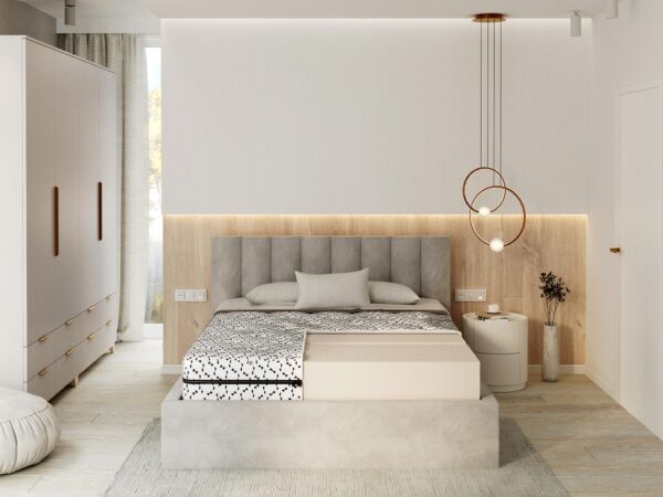 Łóżko w jasnej sypialni z pikowanym zagłówkiem i miękkim materacem