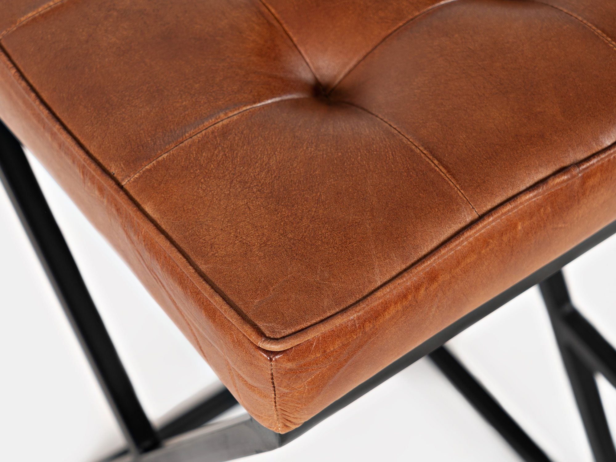 Zbliżenie na siedzisko hokera w brązowej skórze z przeszyciami