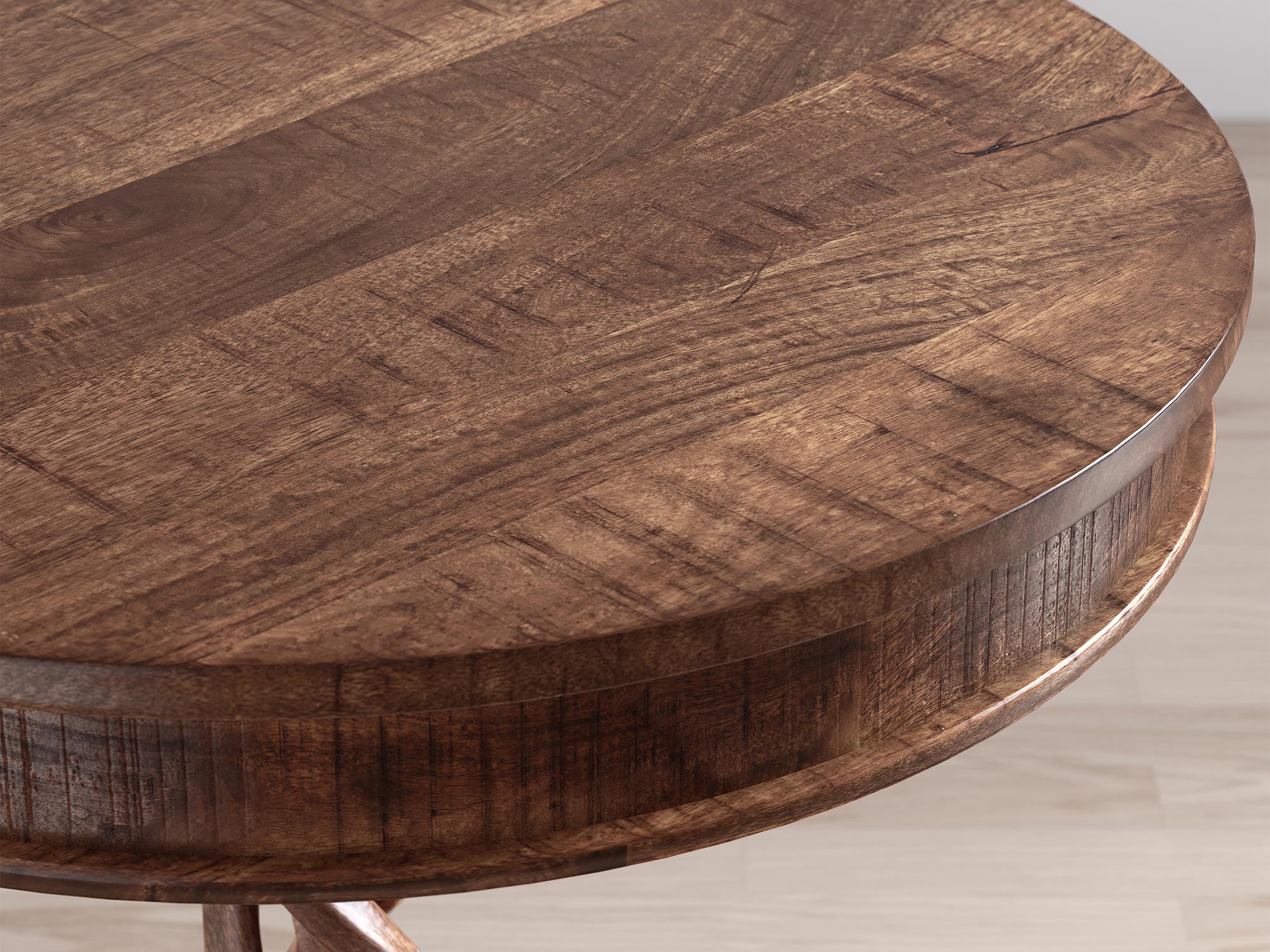 Zbliżenie na brązowy, okrągły blat stołu z widoczną fakturą drewna