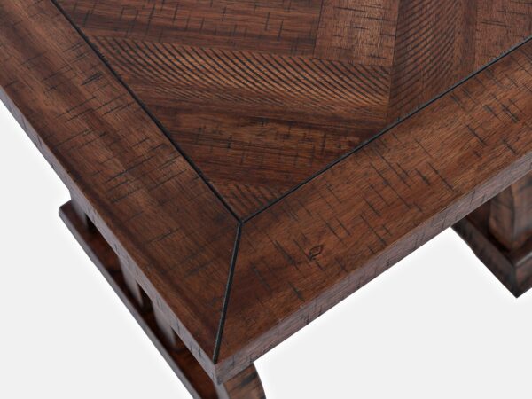 Zbliżenie na narożnik blatu stołu z wzorem jodełki i frezowaną krawędzią