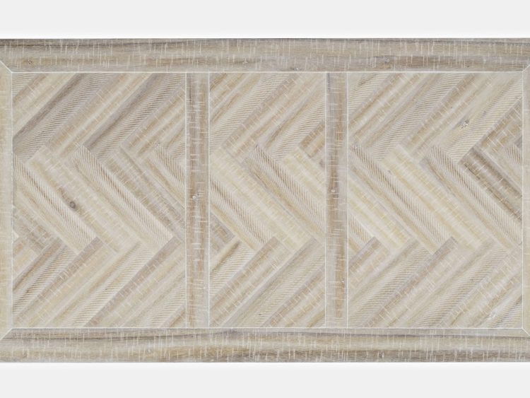 Zbliżenie na blat stołu w bielonym wykończeniu z motywem jodełki