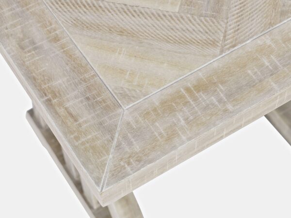 Zbliżenie na blat stołu w bielonym drewnie z widocznym wzorem jodełki