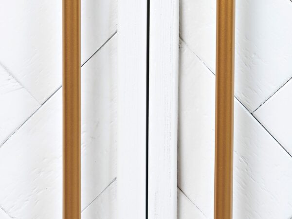 Detal złotych uchwytów w białej komodzie z frezowanym frontem