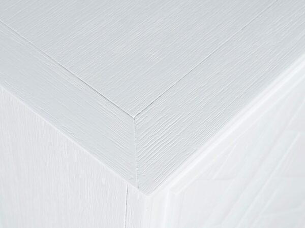 Detal blatu białej komody z frezowanym wykończeniem w stylu glamour