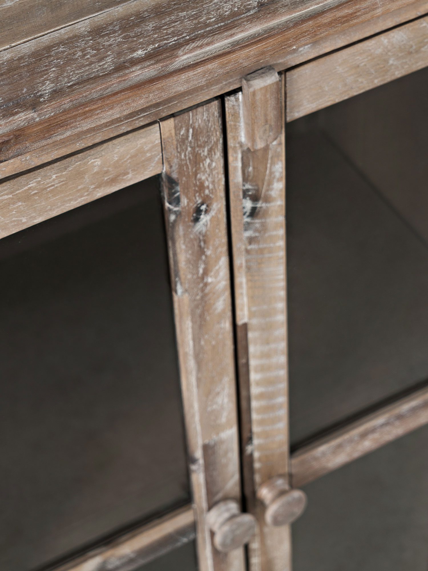 Detal narożnika komody z litego drewna z przeszkleniami