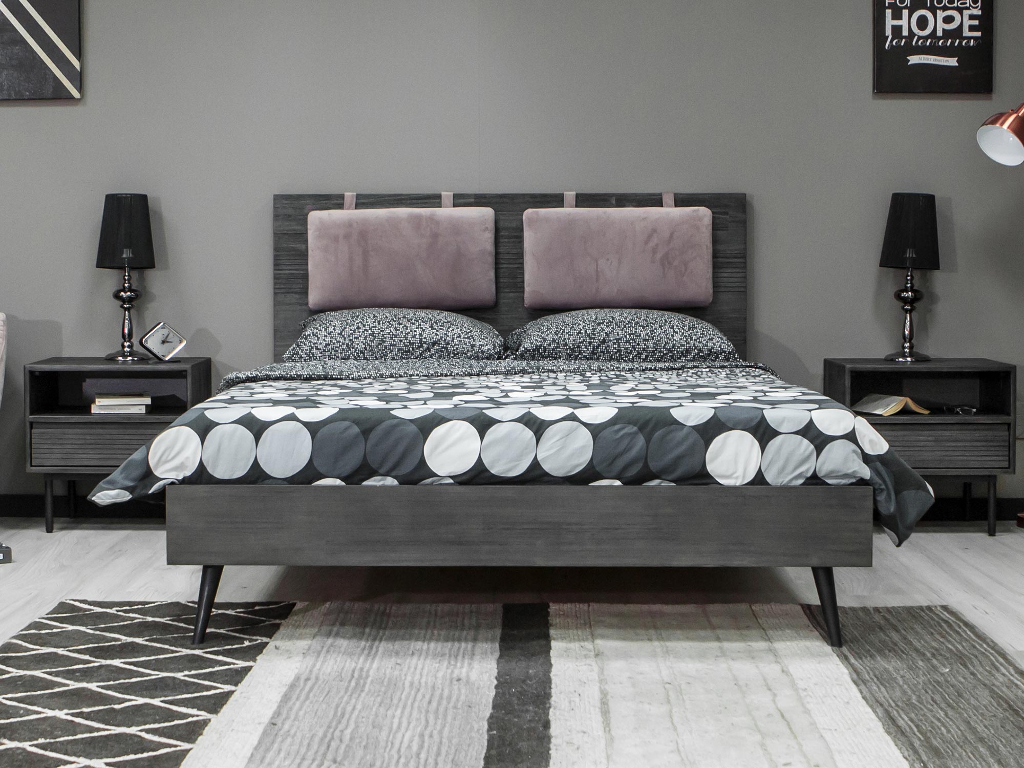 Sypialnia loftowa z czarnym łóżkiem i geometryczną pościelą