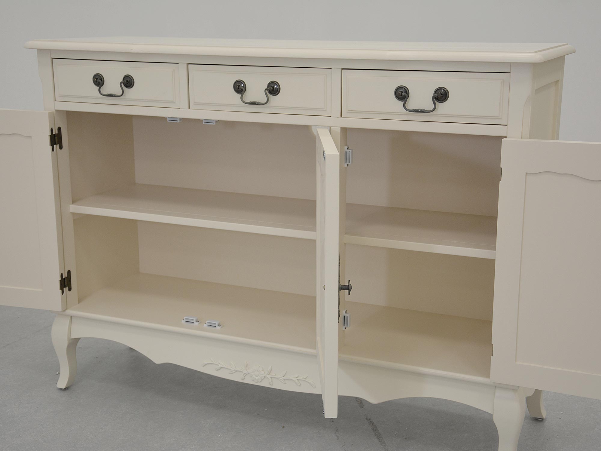 Biała komoda z trzema szufladami i drzwiczkami, widok z otwartymi drzwiami Biała komoda z trzema szufladami i drzwiczkami, widok z otwartymi drzwiami