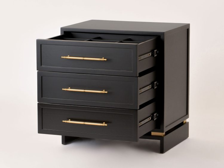 Wnętrze czarnej komody z trzema szufladami i organizacją przegródek.
