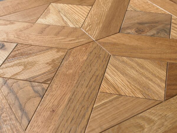 Zbliżenie na blat mebla w jodełkę w kolorze dębu naturalnego