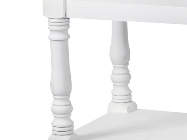 Zbliżenie na rzeźbioną nogę białego regału w stylu vintage