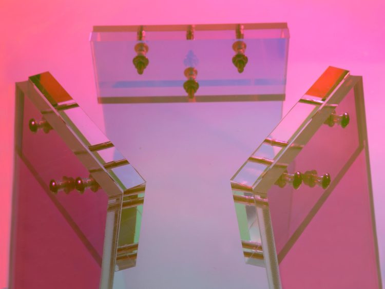 Designerski stolik z barwionymi nogami w odcieniach fuksji i turkusu oraz szklanym blatem