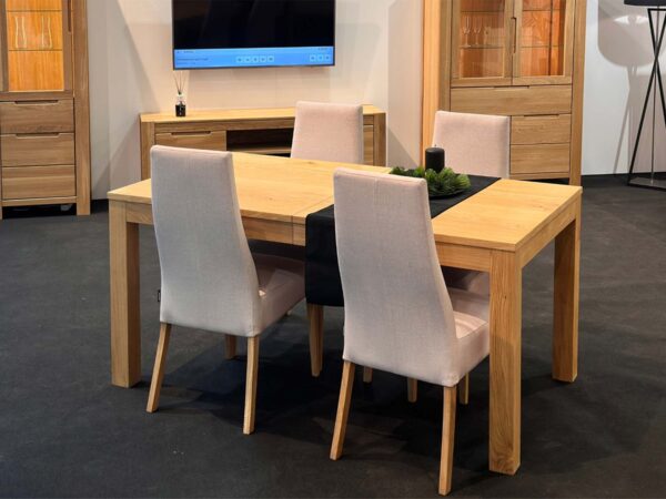 Stół dębowy jadalniany z tapicerowanymi krzesłami w aranżacji showroomu
