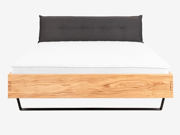 Dębowe łóżko z tapicerowanym zagłówkiem na metalowych płozach