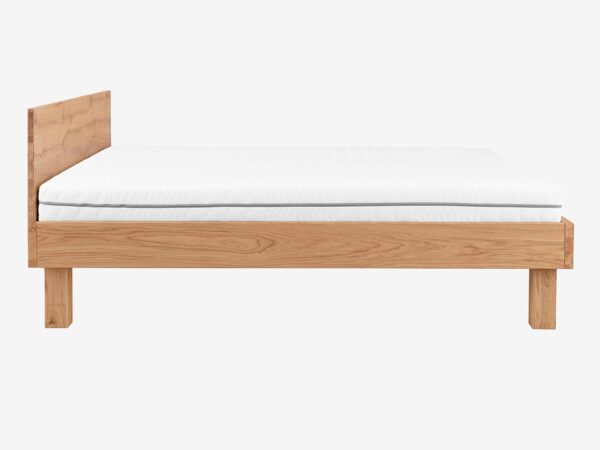 Łóżko drewniane dębowe z pochyłym zagłówkiem i białym materacem